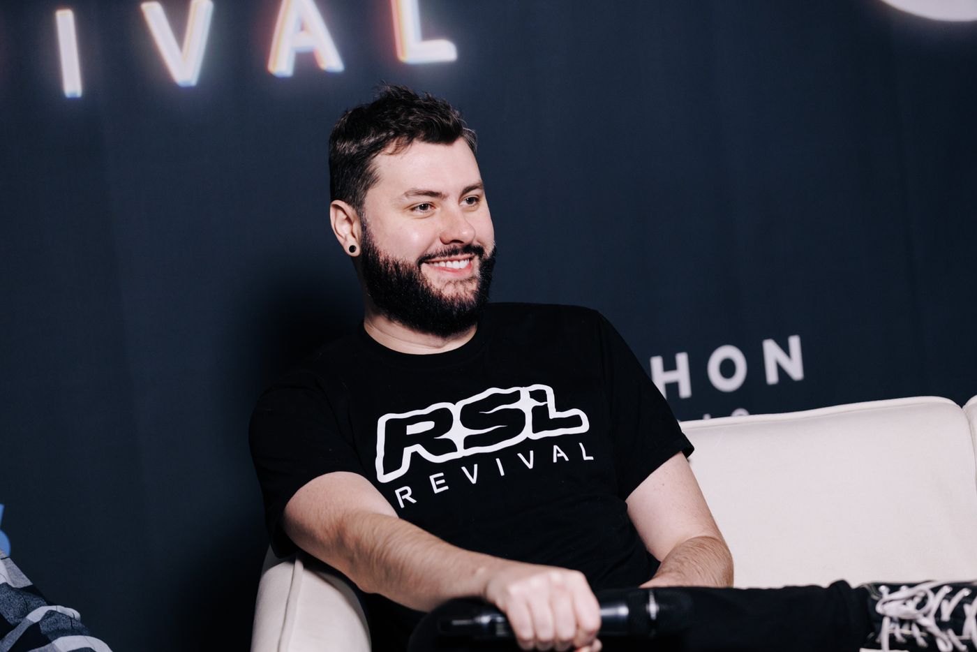 Nick Plott smiling on the RSL Revival broadcast set, wearing an RSL Revival shirt